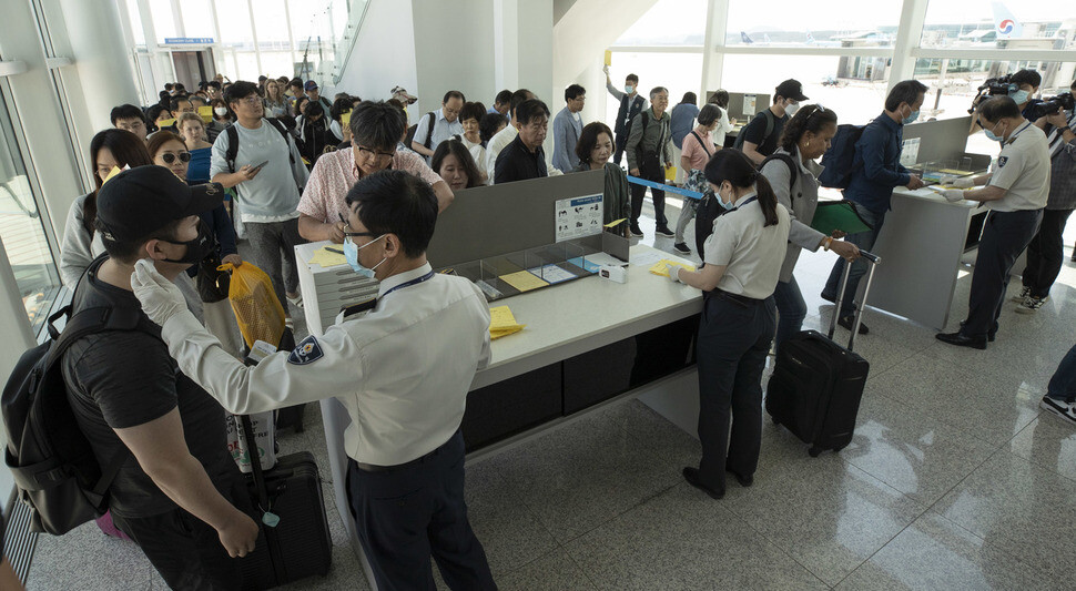 질병관리본부 국립인천공항검역소 검역관들이 10일 낮 인천국제공항 2터미널 안 주기장을 통해 두바이서 온 탑승객들의 체온을 확인하고 있다. 인천공항/김성광 기자 flysg2@hani.co.kr