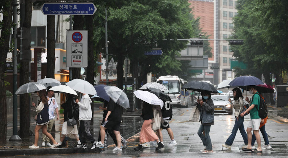 전국 대부분 지역에 비가 내린 28일 오전 우산을 쓴 외국인 관광객들이 서울 청계천로를 걷고 있다. 김정효 기자