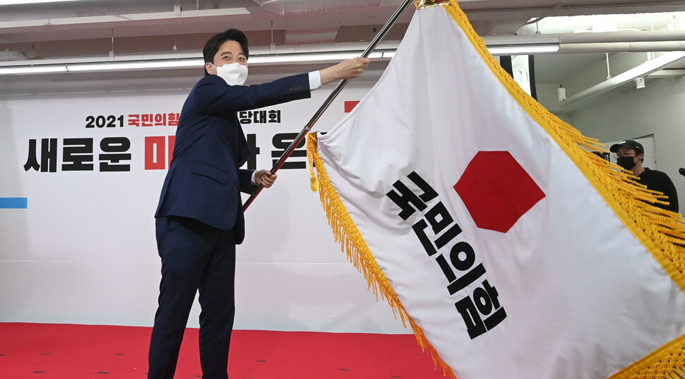 국민의힘 이준석 새 당 대표가 11일 서울 여의도 중앙당사에서 열린 전당대회에서 당기를 흔들고 있다. 공동취재사진