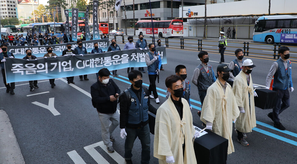 ‘택배노동자 과로사 대책위원회’가 지난 17일 오후 을지로입구에서 CJ대한통운 규탄 대회 뒤 올해 목숨을 잃은 택배노동자 5명의 영정을 들고 행진을 하고 있다. 택배 배송 중 숨진 고 김원종씨 유가족과 시민사회단체 대표 등이 참석했다. 연합뉴스