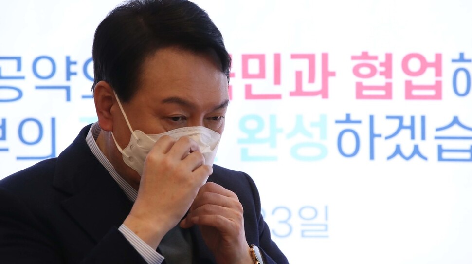국민의힘 윤석열 대선 후보가 23일 서울 여의도 한 카페에서 열린 '국민공약 언박싱 데이' 행사에서 마스크를 고쳐쓰고 있다. 공동취재사진