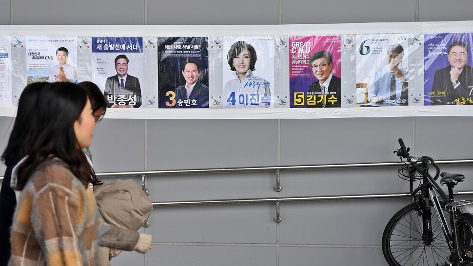 충남대 총장 직선투표가 28일로 다가온 가운데 19일 충남대에서 학생들이 총장선거 공보물을 바라보며 걸어가고 있다.