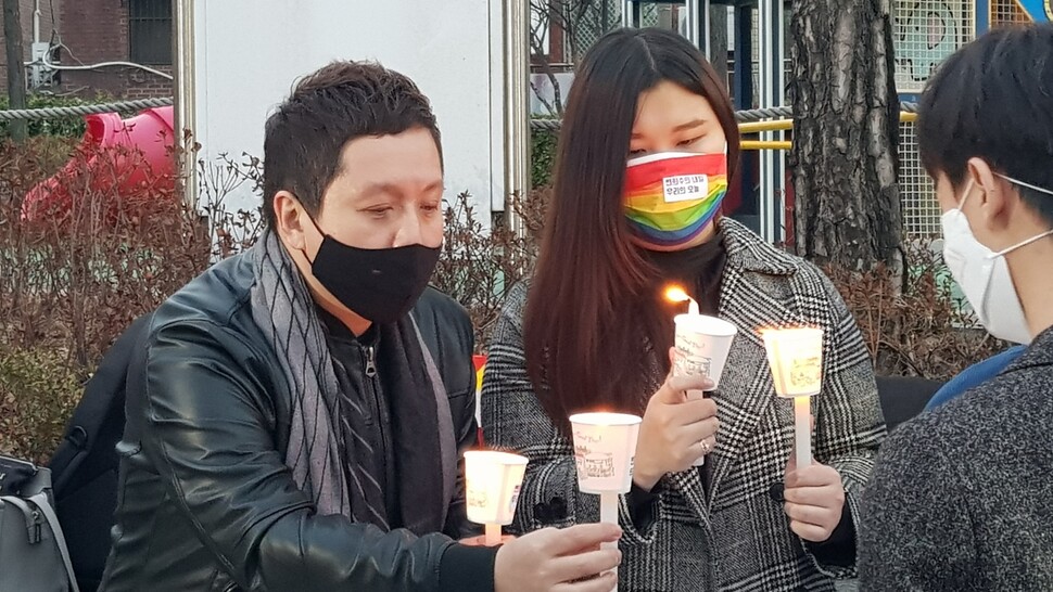 임태훈 군인권센터 소장(왼쪽)과 김겨울 트랜스해방전선 대표가 지난 12일 저녁 서울 국방부 앞에서 열린 변희수 하사를 추모하는 행사에서 참가 시민에게 촛불을 붙여 건네주고 있다. 김종철 선임기자