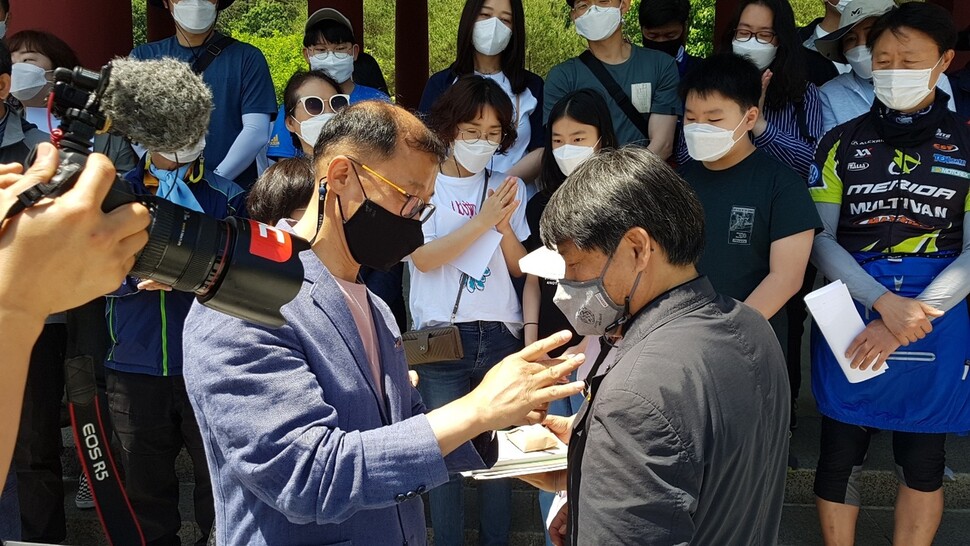 김재옥 전교조 광주지부장(왼쪽)이 19일 국립 5·18묘지 민주의 문에서 임성무 전교조 대구지부장의 윗옷에 5·18 상징 뱃지를 달아주고 있다.