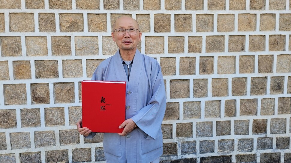 승려 사진작가 관조 스님의 맏상좌 승원 스님이 사진집 &lt;관조&gt;를 들어 보이고 있다. 조현 종교전문기자