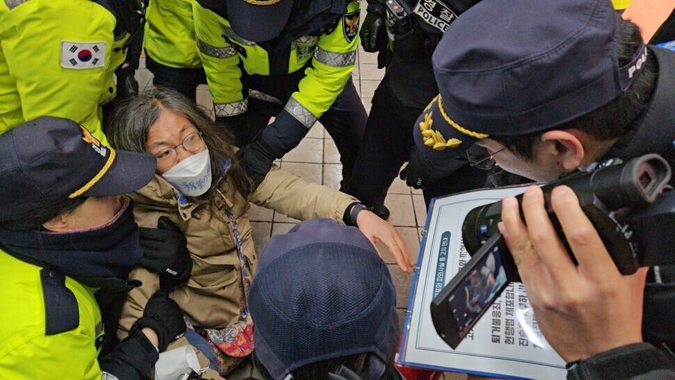 지난 15일 서울지하철 4호선 혜화역 역사 안에서 침묵시위를 하던 전장연 활동가가 경찰에 연행되고 있다. 김채운 기자