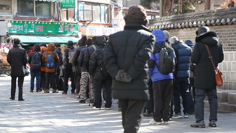 25일 낮 서울 종로구 탑골공원 원각사 무료급식소 앞에 노인들이 점심을 먹기 위해 기다리고 있다. 박종식 기자