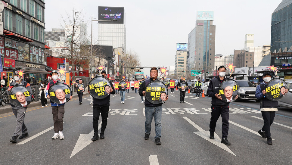 집회를 마친 참가자들이 ‘윤석열이 폭탄이다’라고 적힌 폭탄 모양 손팻말을 들고 행진하고 있다. 신소영 기자