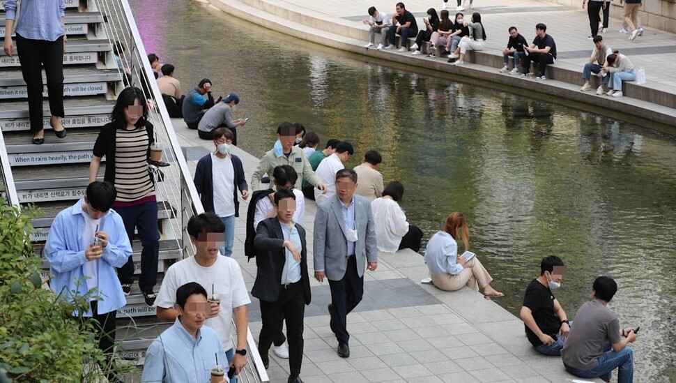 야외에서 마스크 착용이 모임 인원과 장소 상관없이 모두 ‘자율’로 바뀐 26일 마스크를 벗은 직장인들이 서울 청계천을 산책하고 있다. 김정효 기자