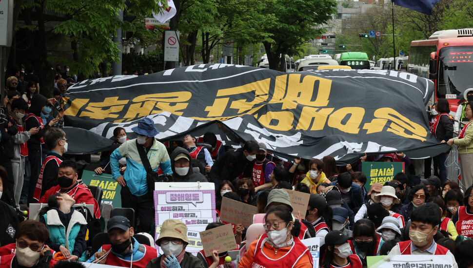 20일 서울 영등포구 63스퀘어 앞에서 열린 ‘장애인의 날을 거부하는 자들의 제22회 장애인차별 철폐의 날 기념식’에서 참석자들이 '예산 없이 권리 없다 장애인 권리 예산 보장하라'라는 문구가 적힌 대형 펼침막을 파도타기하는 행위극을 하고 있다. 김혜윤 기자