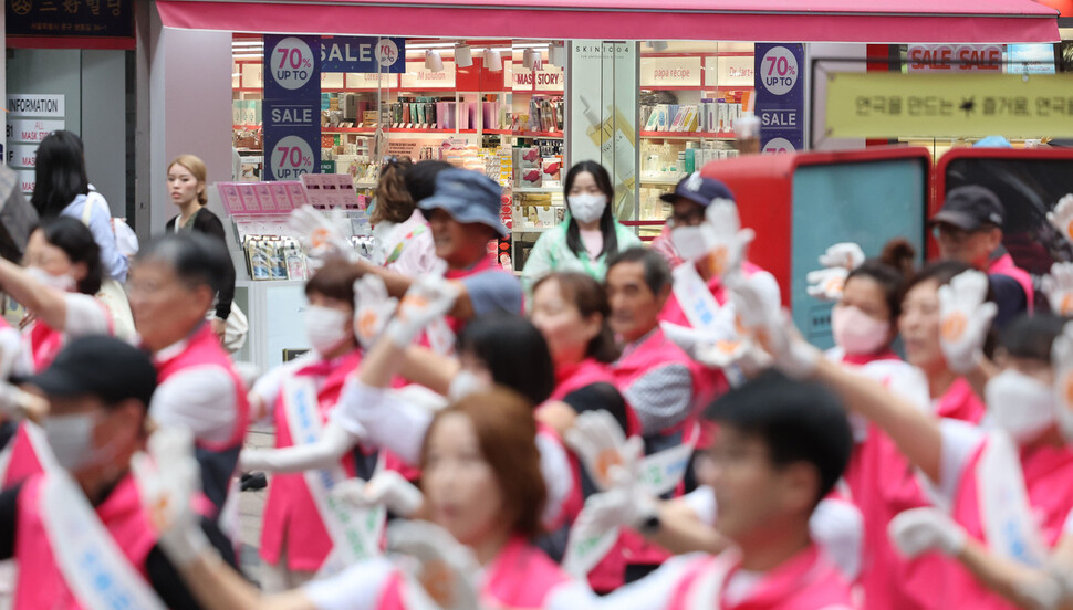 20일 오후 서울 중구 명동예술극장 앞에서 에너지절약 메시지를 담은 플래시몹을 하는 에너지서울동행단 뒤로 한 가게가 문을 연 채 냉방을 하며 영업하고 있다. 백소아 기자 thanks@hani.co.kr