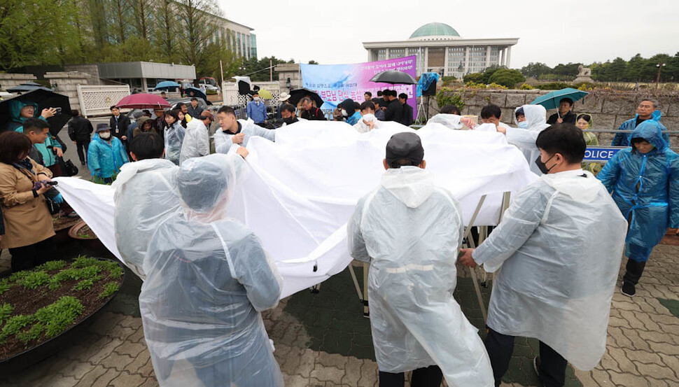 유가협과 민주유공자법 제정 추진단 관계자들이 11일 오후 국회 앞 민주유공자법 제정 촉구 단식 농성 천막을 설치하고 있다. 김정효 기자