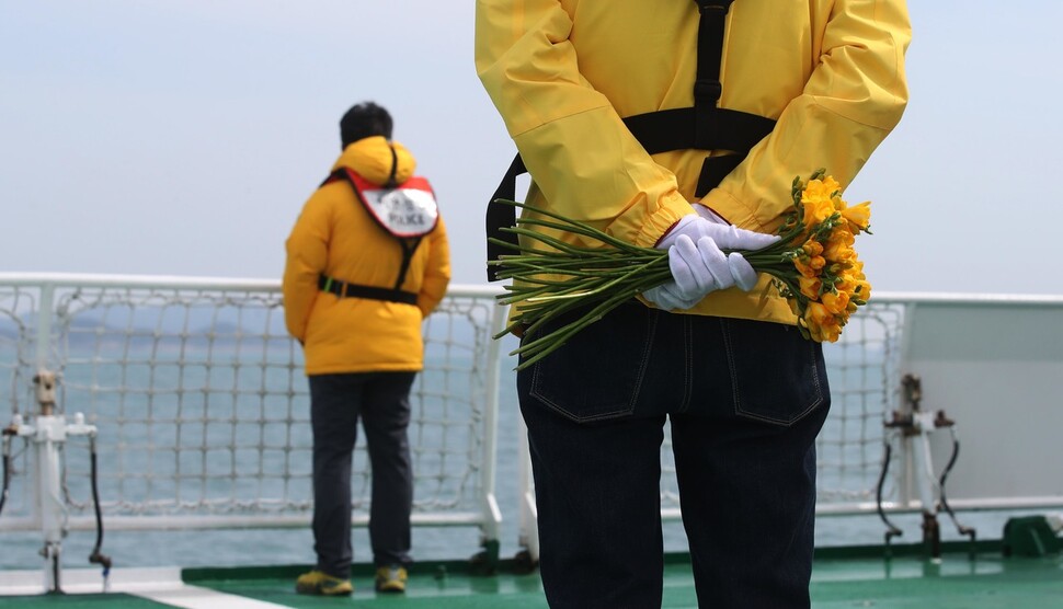 10일 오전 전라남도 진도 앞바다 세월호 참사 해역에서 열린 세월호 8주기 선상추모식에서 한 유가족이 손에 노란색 프리지어를 든 채 바다를 바라보고 있다. 진도/백소아 기자