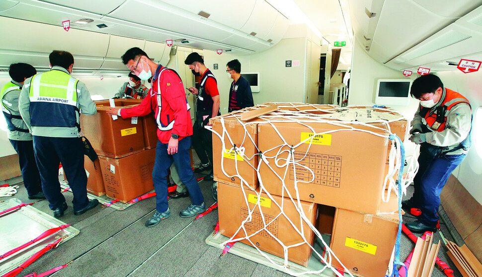 2020년 9월 24일 인천국제공항 1터미널에서 아시아나항공 관계자들이 A350 여객기에 화물을 탑재하고 있다. 아시아나항공은 2분기 실적 호조세를 이어가기 위해 A350-900 여객기 1대의 이코노미 좌석 283석을 화물탑재 공간으로 개조했다. 이번 개조로 5톤의 추가 화물을 적재해 편당 23톤의 화물 수송이 가능하다. 공항사진기자단.