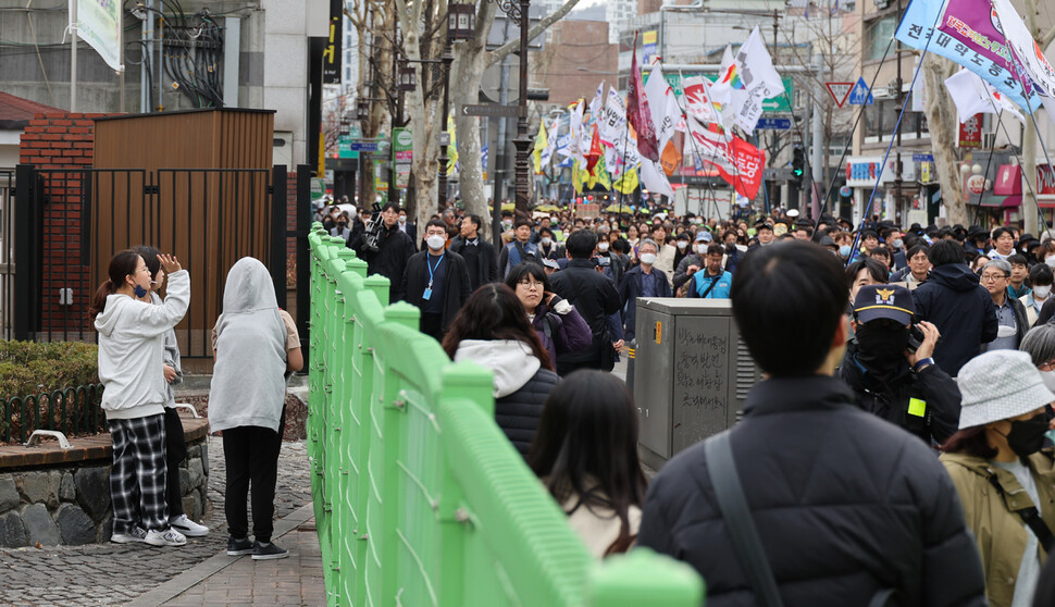 2023년 3.8세계여성의날 정신계승 전국노동자대회가 열린 8일 오후 서울 종로구 보신각에서 참가자들이 대학로를 향해 행진하는 모습을 효제초등학교 여학생들이 지켜보고 있다. 김혜윤 기자