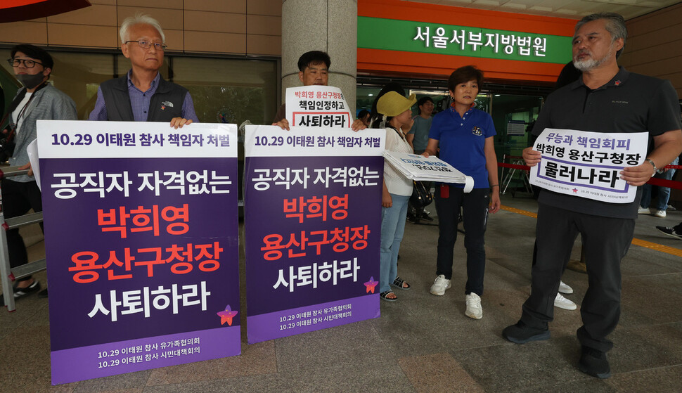 ‘이태원 참사’와 관련해 업무상 과실치사 등의 혐의로 재판을 받고 있는 박희영 서울 용산구청장에 대한 공판이 열린 18일 오후 서울 마포구 공덕동 서울서부지방법원 앞에서 박 구청장이 법원 청사 안으로 들어간 뒤 유가족들이 손팻말을 들고 박 구청장의 사퇴를 요구하고 있다. 김정효 기자