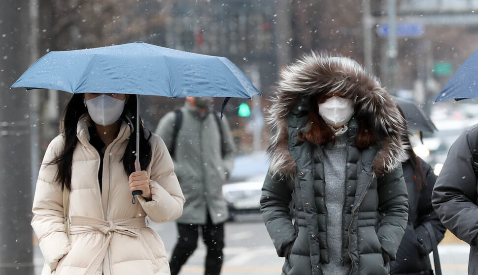 서울 지역에 눈이 내린 6일 오전 시민들이 서울 광화문에서 건널목을 건너고 있다. 김정효 기자 hyopd@hani.co.kr