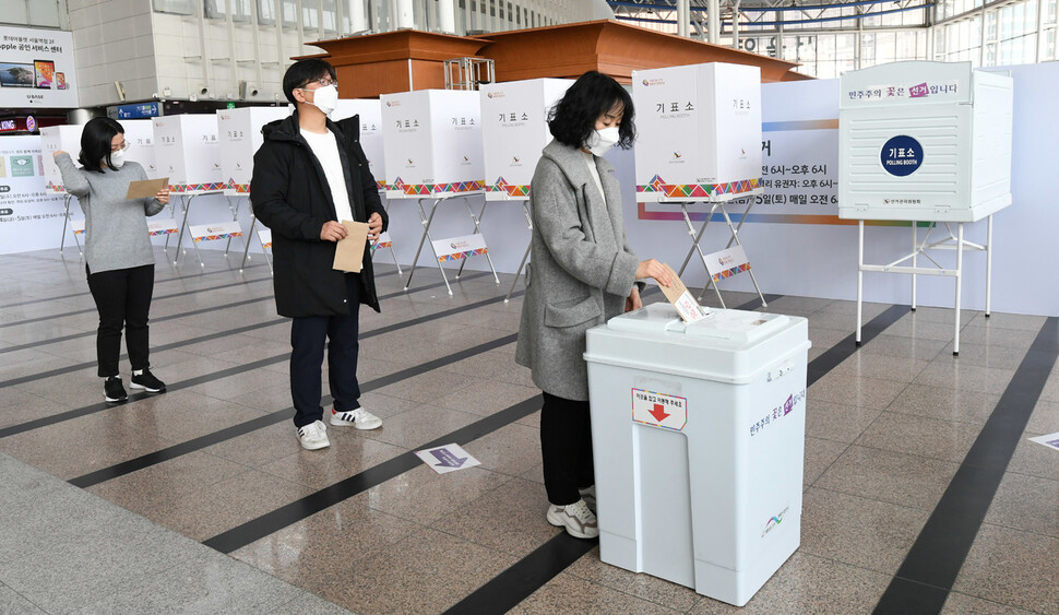 3일 서울 용산구 ‘서울역 남영동 사전투표소’에서 선관위 관계자들이 모의 투표용지를 투표함에 넣고 있다. 공동취재사진