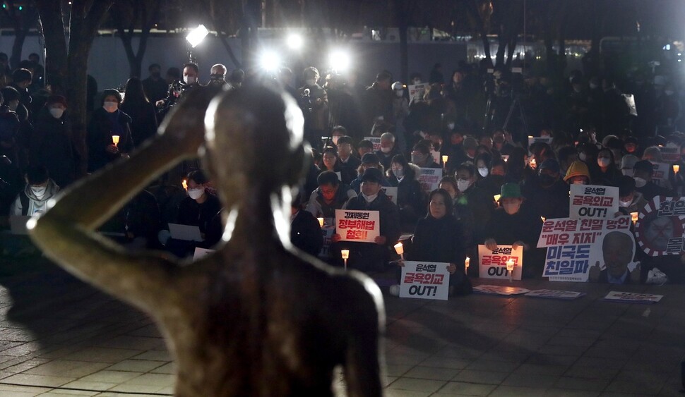 6일 저녁 서울시청 광장에서 ‘강제동원 정부해법 강행 및 친일 굴욕외교 규탄 긴급 촛불시위’가 열려 참가자들이 강제징용 노동자상 앞에서 손팻말과 촛불을 들고 있다. 윤운식 선임기자 yws@hani.co.kr