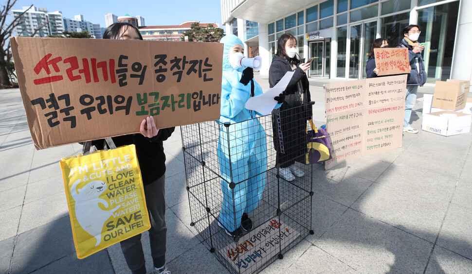 대학생연합환경동아리 &lt;에코로드&gt; 회원들이 9일 오후 서울 성동구 이마트 본사 앞에서 플라스틱 어택의 일환으로 쓰레기 더미에 빼앗긴 인간의 보금자리를 표현하는 행위극을 하고 있다. 백소아 기자