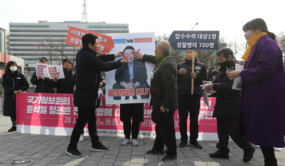 19일 오후 서울 용산구 대통령실 앞에서 열린 국가정보원의 민주노총 압수수색 규탄 및 윤석열 정권의 진보진영 공안탄압 중단 촉구 시민사회노동종교단체 공동 기자회견을 마친 참가자들이 윤석열 대통령 얼굴 손팻말 위로 엑스 스티커를 붙이는 행위극을 하고 있다. 신소영 기자