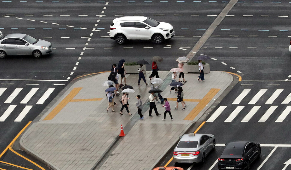 전국 곳곳에 소나기가 내린 9일 낮 서울 광화문 네거리에서 시민들이 우산을 들고 건널목을 건너고 있다. 강창광 기자&nbsp;