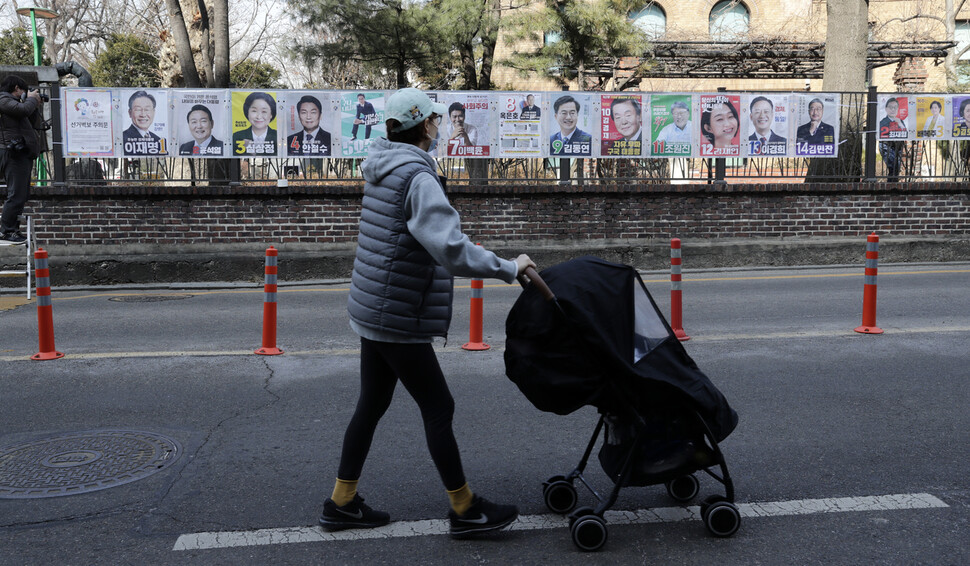 18일 오전 서울 종로구 이화동 거리에 설치된 20대 대통령선거 후보자의 선거벽보 앞으로 한 시민이 지나가고 있다.