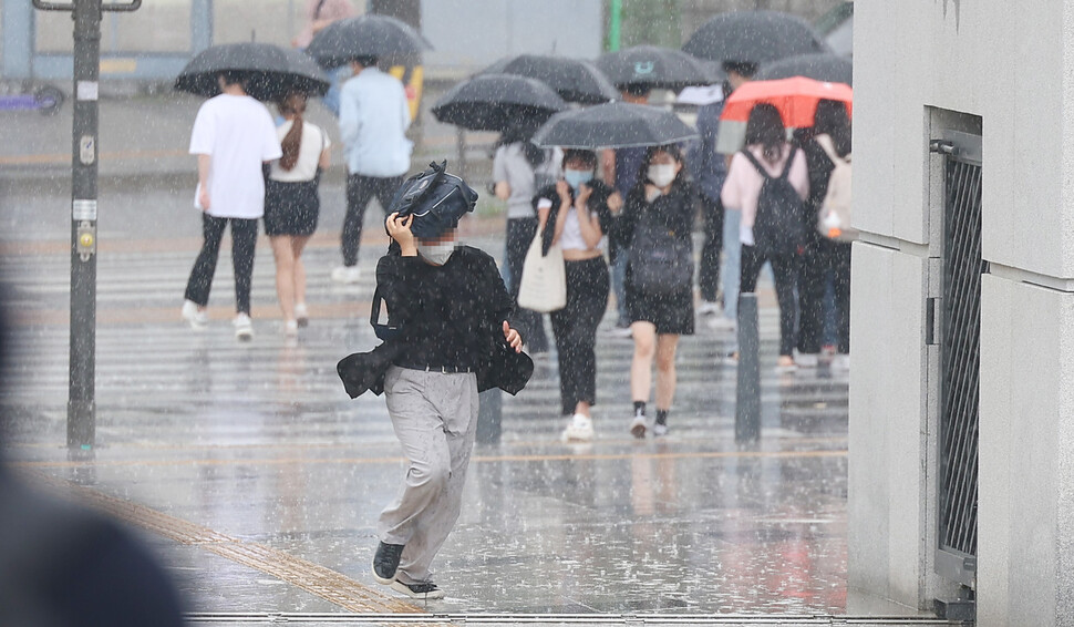 서울에 비가 내린 지난 9일 오후 서울 서대문구 연세대학교에서 한 시민이 가방으로 비를 막으며 뛰어가고 있다. 연합뉴스