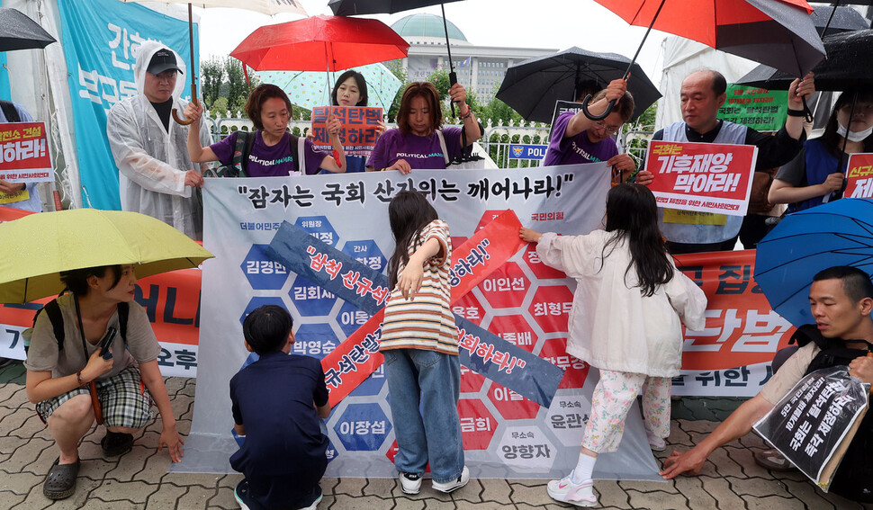 11일 오후 서울 영등포구 국회 앞에서 열린 신규석탄발전중단법 제정 촉구 기자회견에서 어린이들이 국회 산업통상자원중소벤처기업위원회 의원 명단이 적힌 현수막에 삼척 석탄발전소 철수하라고 적힌 스티커를 부착하는 행위극을 하고 있다. 김경호 선임기자