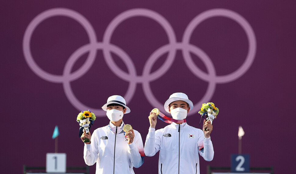 양궁 국가대표 김제덕(오른쪽)과 안산이 24일 일본 도쿄 유메노시마 공원 양궁장에서 열린 도쿄올림픽 혼성 결승전에서 금메달을 목에 걸고 포즈를 취하고 있다. 도쿄/연합뉴스