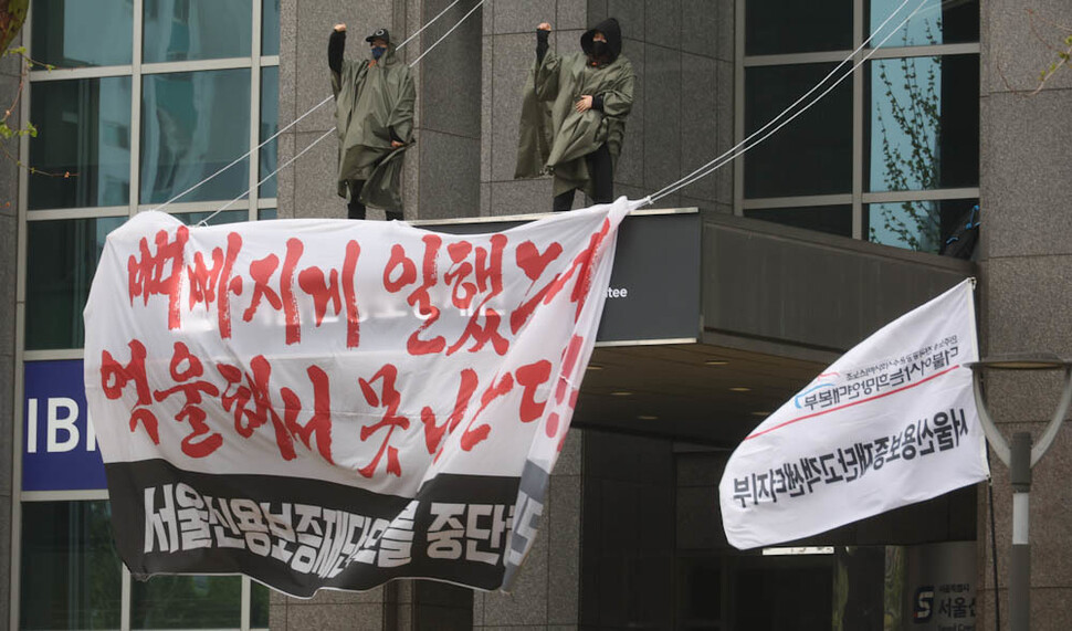 서울신용보증재단고객센터지부 박영임 정책부장(왼쪽)과 진기숙 조직부장이 18일 오전 서울 마포구 서울신용보증재단 건물 캐노피에 올라 해고 철회를 요구하는 농성을 벌이고 있다 . 김정효 기자