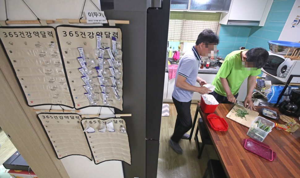 시설장과 재활 당사자가 식사를 준비하고 있다. 벽에는 재활 당사자들의 약을 담은 약달력이 보인다. 이정용 선임기자 lee312@