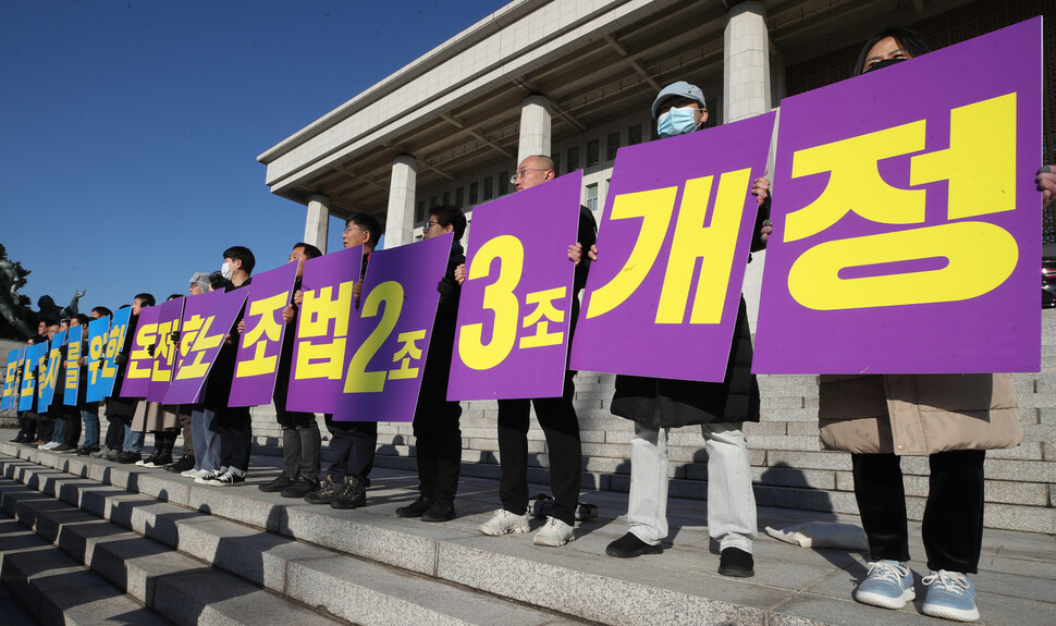 21일 오전 국회 본관 앞 계단에서 노조법2·3조 개정 운동본부 기자회견이 열려 참석자들이 법안의 온전한 국회 통과를 촉구하는 손팻말을 들고 있다. 신소영 기자