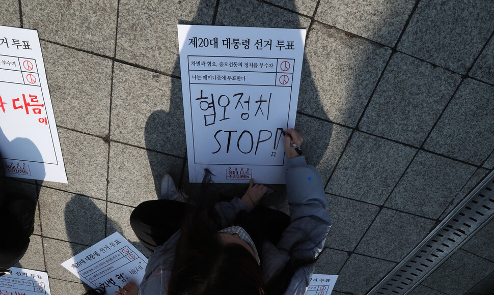 ‘2022 페미니스트 주권자행동' 회원들이 12일 오후 보신각 앞에서 ‘차별과 혐오, 증오선동의 정치를 부수자'를 주제로 열린 집회에서 대선후보들에게 보내는 문구를 적고 있다. 박종식 기자 anaki@hani.co.kr