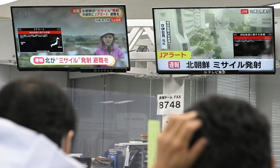 31일 일본 도쿄에서 주민들이 TV에 뜬 북한 미사일 관련 속보를 바라보고 있다. 이날 오전 일본 정부는 전국순시경보시스템(J-ALERT)을 통해 대피 명령을 내렸지만 약 30분 만에 해제했다. 도쿄/AP 연합뉴스