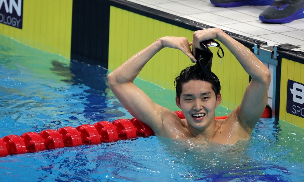 김우민이 28일 중국 항저우의 올림픽 스포츠센터에서 열린 2022 항저우아시안게임 수영 경영 남자 자유형 800m 결선에서 금메달을 확정짓고 하트를 그리고 있다. 항저우/연합뉴스