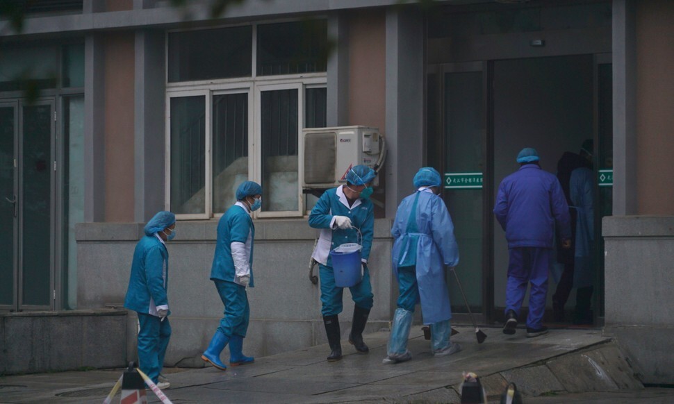 신종 코로나바이러스로 인한 ‘우한 폐렴’이 발생한 중국 후베이성 우한에서 의료진이 폐렴 환자들을 집중 치료하고 있는 한 병원의 들머리를 소독하고 있다. 우한/AP 연합뉴스