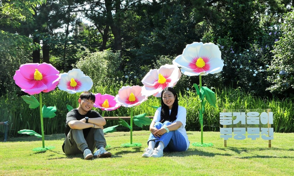 무궁화축제가 열리는 충남 태안 천리포수목원 무궁화동산의 포토존에서 지난 3일 이 수목원 실습생들이 축제 홍보 촬영을 하고 있다. 천리포수목원 제공