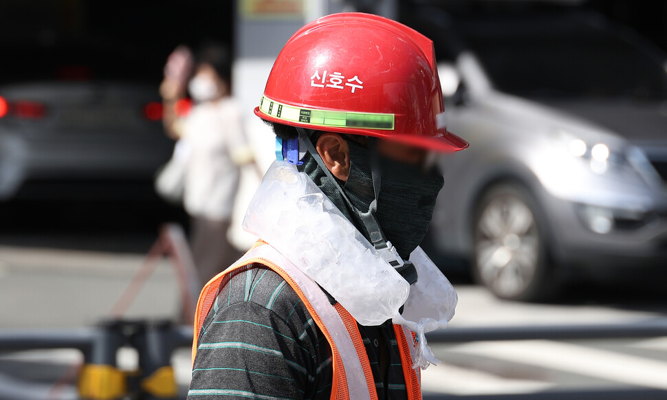 지난 4일 대구 중구의 한 공사장에서 근로자가 목에 얼음 주머니를 두르고 더위를 이겨내고 있다. 연합뉴스