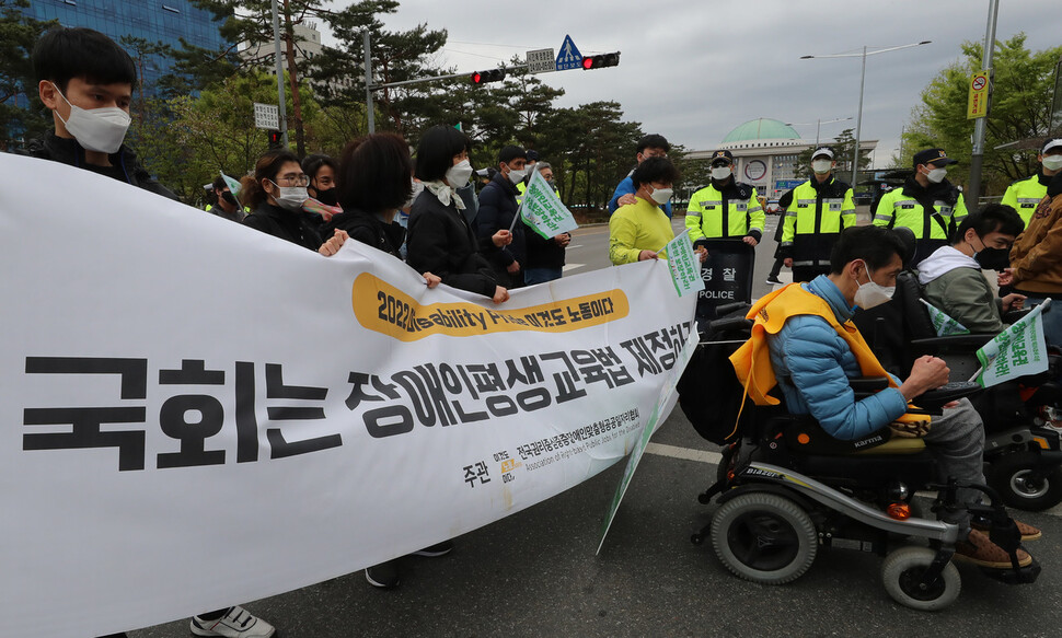 참가자들이 국회에 장애인교육 관련 법안 제정을 촉구하는 내용이 적힌 펼침막을 들고 행진하고 있다. 신소영 기자