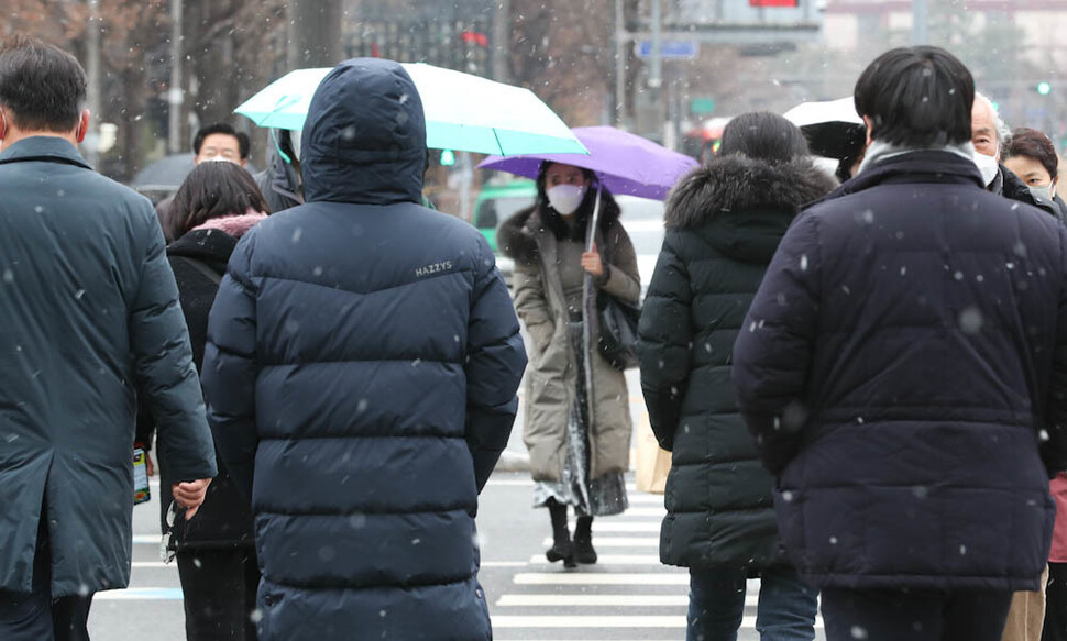 서울 지역에 눈이 내린 6일 오전 시민들이 서울 광화문에서 건널목을 건너고 있다. 김정효 기자