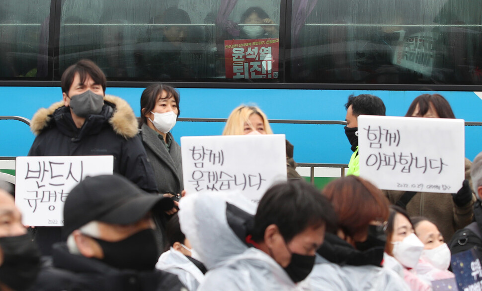 14일 오후 서울 용산구 전쟁기념관 앞에서 10.29 이태원 참사 유가족협의회·10.29 이태원 참사 시민대책회의 주최 3차 시민추모제가 열리는 동안 버스를 타고 인근에서 열리는 집회로 이동하던 한 시민이 차장 너머로 추모제를 바라보고 있다. 신소영 기자