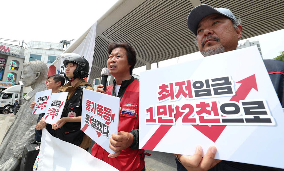 민주노총 공공운수노조 관계자들이 18일 오전 서울 중구 청계천 전태일다리에서 ‘최저임금 투쟁선포 기자회견’을 열어 최저임금을 1만2000원으로 올릴 것을 요구하고 있다. 김정효 기자