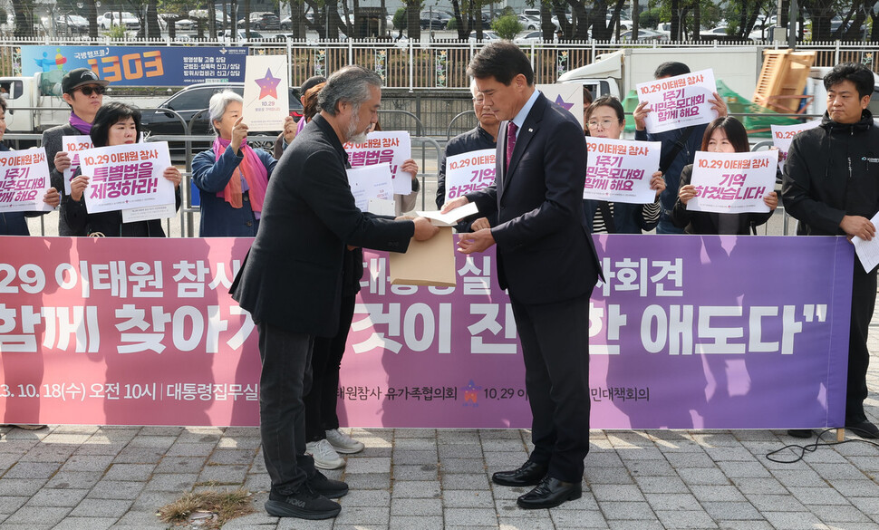 10·29 이태원 참사 유가족과 시민대책회의 구성원들이 18일 오전 서울 용산구 대통령실 앞에서 참사 1주기 기자회견을 마친 뒤 윤석열 대통령에게 보내는 10·29 이태원 참사 1주기 시민추모대회 초청장을 신진영 시민사회수석실 행정관(오른쪽)에게 전달하고 있다. 백소아 기자