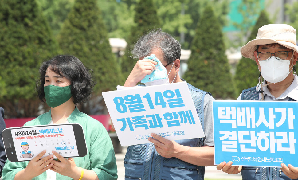 진경호 전국택배연대노동조합 수석부위원장(가운데)이 9일 오전 서울 종로구 광화문광장에서 열린 기자회견 ‘8월 14일을 택배 없는 날로 지정하라!'’에서 땀을 닦고 있다. 백소아 기자