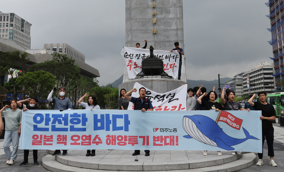 민주노총 조합원들이 일본의 후쿠시마 오염수 배출을 규탄하며 이순신 장군 동상에 올라 구호를 외치고 있다. 신소영 기자