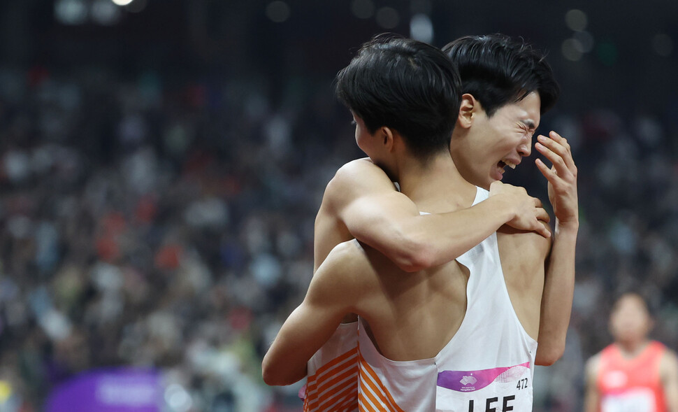 3일 중국 항저우 올림픽 스포츠센터에서 열린 2022 항저우 아시안게임 남자 400ｍ 계주 결선에서 한국 마지막 주자인 고승환이 3위로 결승선을 통과한 뒤 이정태와 포옹을 하고 있다. 항저우/연합뉴스