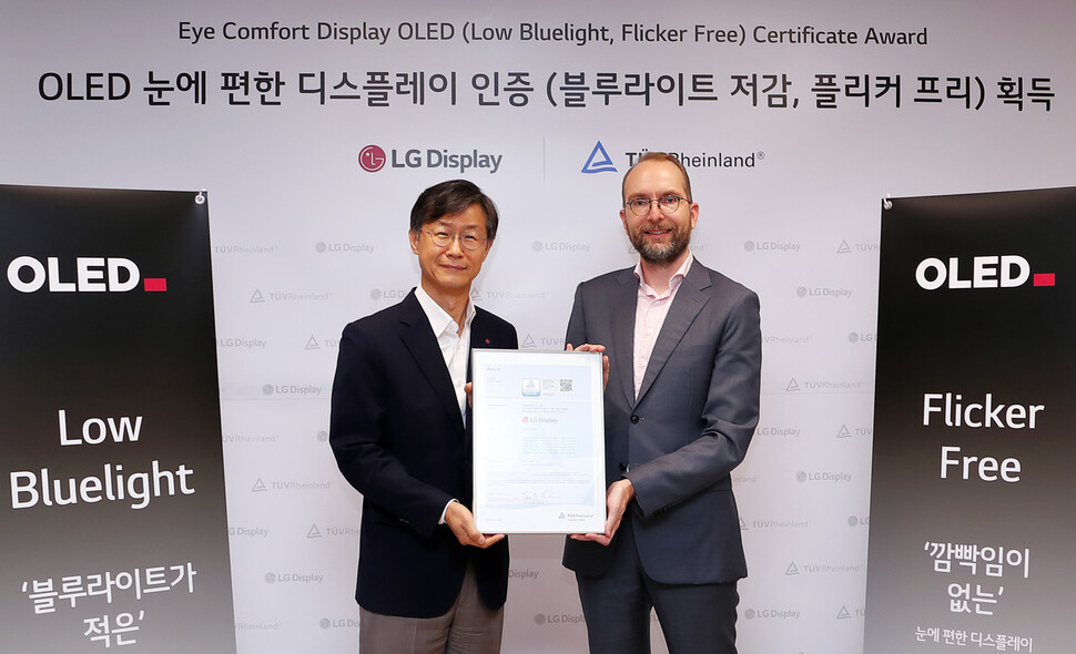 지난 6월30일 여의도 LG트윈타워에서 열린 LG디스플레이 OLED TV 패널 ‘플리커 프리’ 인증식에서 LG디스플레이 오창호 TV사업부장 부사장(왼쪽)과 티유브이 라인란드 Carsten Lienemann 한국 대표이사가 기념촬영을 하고 있다. LG디스플레이 제공