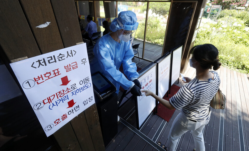 22일 오전 서울 송파구 보건소 코로나19 선별진료소에서 검사를 받으려는 한 시민이 번호표를 받고 있다. 김혜윤 기자