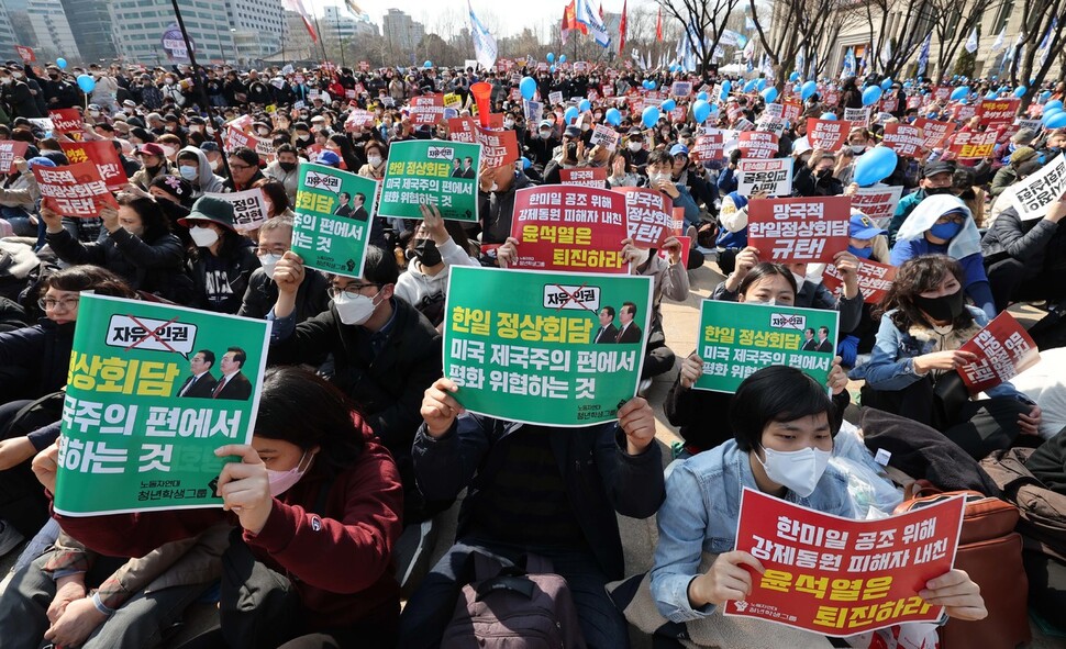 18일 오후 서울시청 광장에서 '강제동원 해법 및 한일정상회담을 규탄하는 3차 범국민대회'가 열려 참가자들이 한일정상회담 규탄 손팻말을 들고 구호를 외치고 있다. 박종식 기자